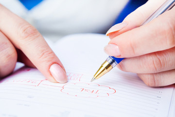 Business Woman Writing with pen in notepad