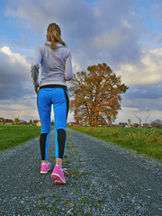 Female running in nature on a long road