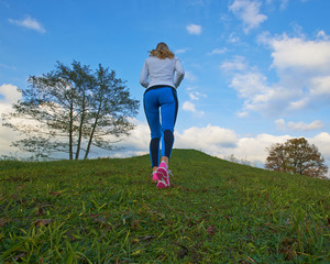 Pretty female going up the hill to clouds