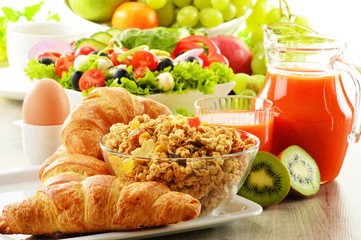 Breakfast with coffee, juice, croissant, salad, muesli and egg