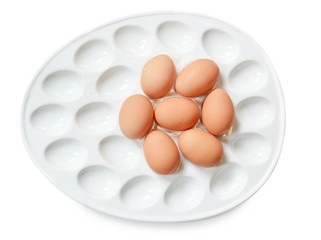 Lot of brown eggs in a row on a tray.