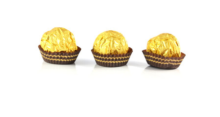 Sweet chocolate candy wrapped in golden foil isolated on white b
