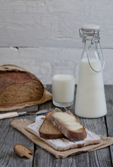 Black rustic bread and a bottle of milk