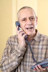 Handsome and amicable man speaking softly with a friend on the phone