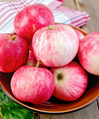 Apples red in a bowl on the board