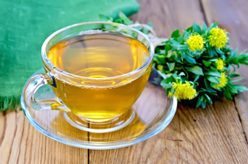 Herbal tea with a bouquet of Rhodiola rosea on the board