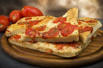 Focaccia with tomatoes and oregano close up