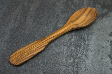 Wood spoon made with olive plant on gray background