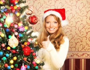 A happy teenage girl decorating the Christmas tree
