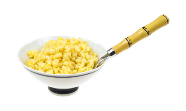 Buttered shoepeg corn in a bowl with a spoon