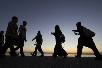 Silouetes of people walking on the sunset