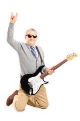 Cool senior man with an electric guitar giving a hand sign