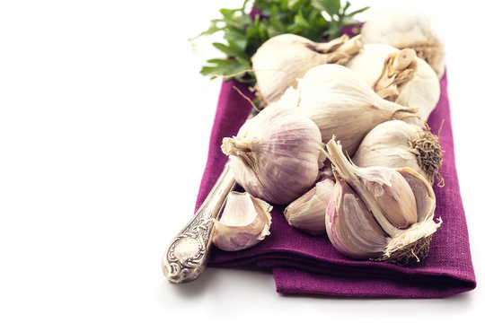Garlic on violet towel on white
