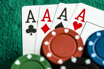 four aces with casino chips on green table