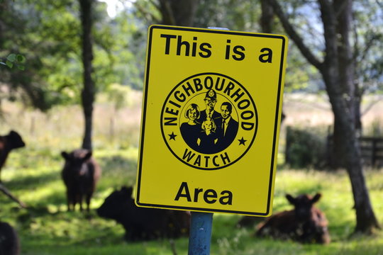 Neighborhood watch sign in cow paddock, Scotland