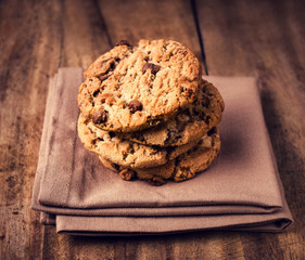 Stacked chocolate chip cookies on brown napkin