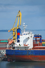 Naklejka premium Bulk cargo ship under port crane bridge, Odessa, Ukraine