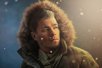 Portrait of brutal sexy man outdoors in winter under snowstorm