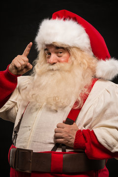 Santa Claus have an idea gesturing with finger against dark back