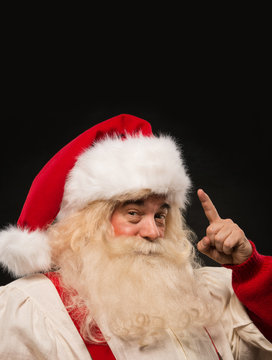 Santa Claus have an idea gesturing with finger against dark back