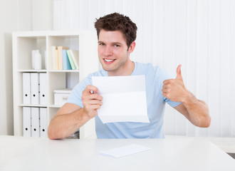 Happy Man Looking At Paper