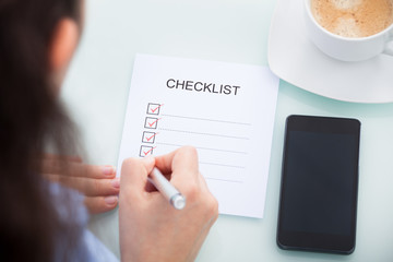 Businesswoman Marking On Checklist