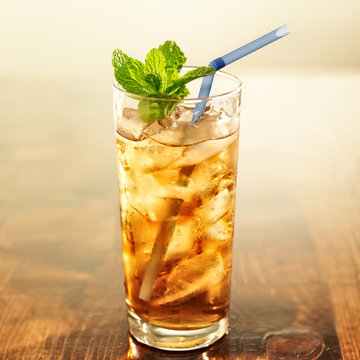 golden iced tea with blue straw and mint