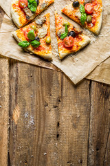 Fresh pizza on paper and old wooden table as background 8