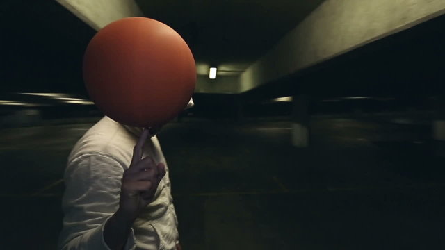 Hooded Basketball player spinning a basketball at night