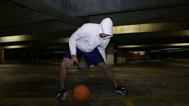 Male Basketball player practicing his skills at night