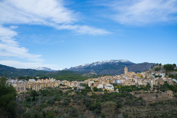 Fototapeta na wymiar Mediterranean village surrounded by snow caped mountains