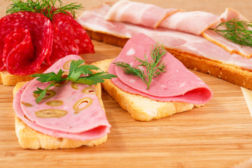Sandwiches with salami, bacon and mortadella
