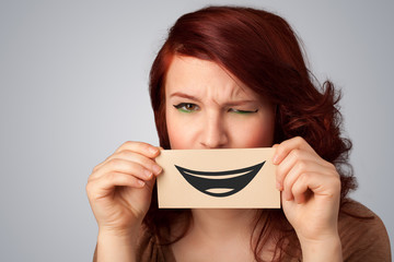 Happy pretty woman holding card with funny smiley
