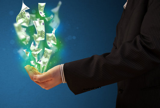 Glowing money in the hand of a businessman