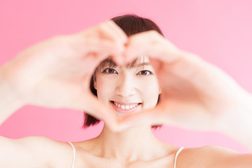 Naklejka premium 手でハートを作る女性