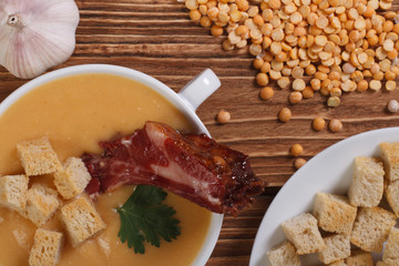 Hot pea soup with smoked meat and garlic
