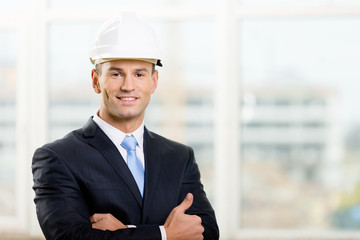 Portrait of engineer in hard hat with his arms crossed