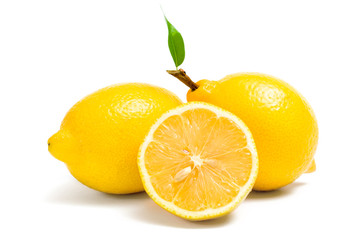 Close up of three lemons and one is cut, isolated
