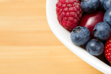 Close up view of part of plate full of berries on the table