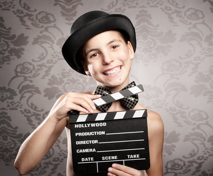 happy little girl holding a movie clapper