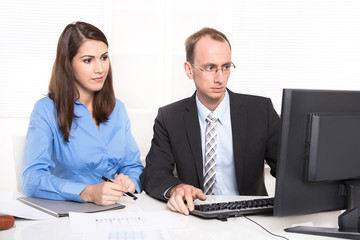 Obraz premium Two business people sitting at desk.