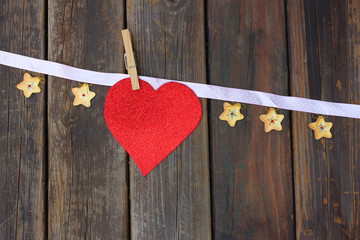 Red paper heart hanging on ribbon with small starts