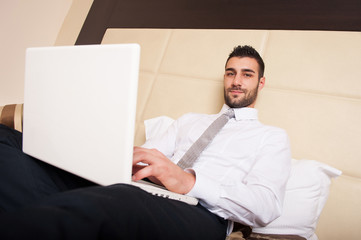 Young businessman working with computer in hotel room.