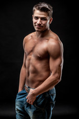 Fototapeta na wymiar young muscular man on dark background