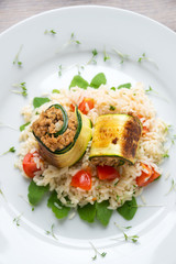 Tomaten-Reis auf Ruccola mit vegetarischen Zucchiniröllchen