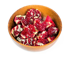broken pomegranate in a wooden bowl