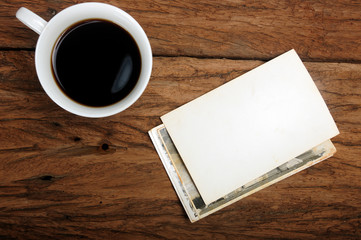 cup of coffee and old paper photo frame on wood background