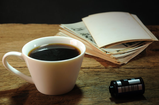 cup of coffee and old paper photo frame on wood background