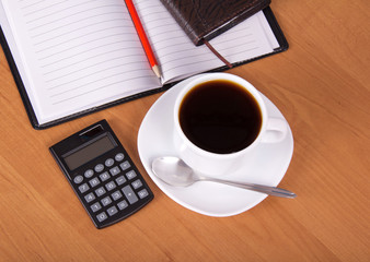 Open notepad, calculator, cup of coffee