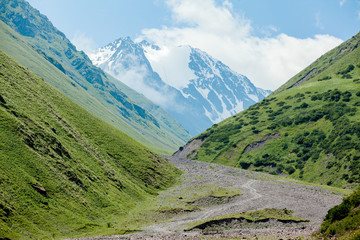 Stony road and white mountain peak